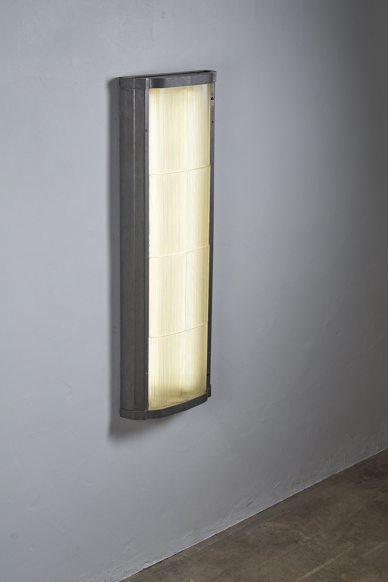 Industrial mount with glass diffuser illuminating a modern interior wall