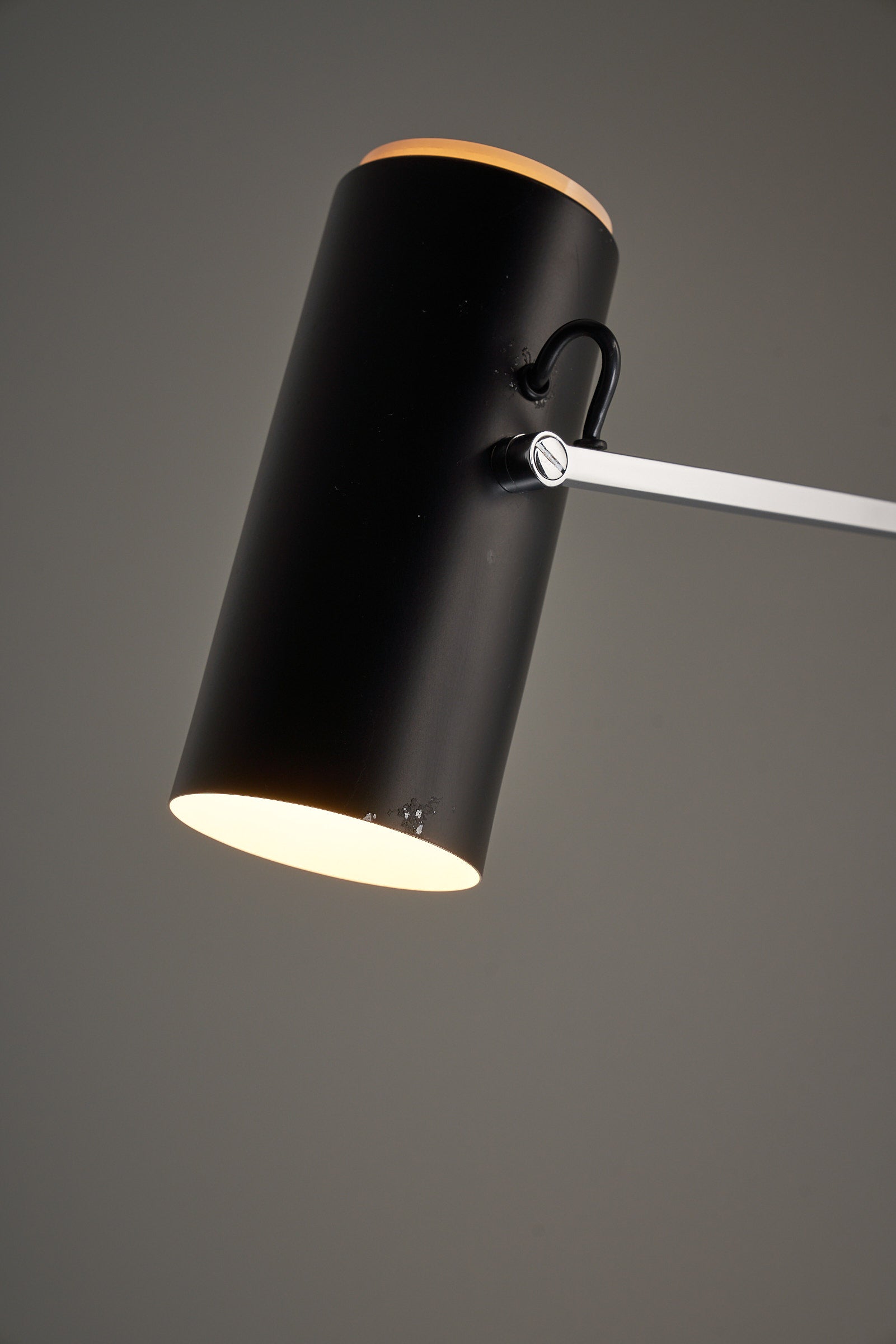 Close-up view of Directional Wall Spot by Cosack Leuchten featuring black cylindrical shade and adjustable chrome arm.