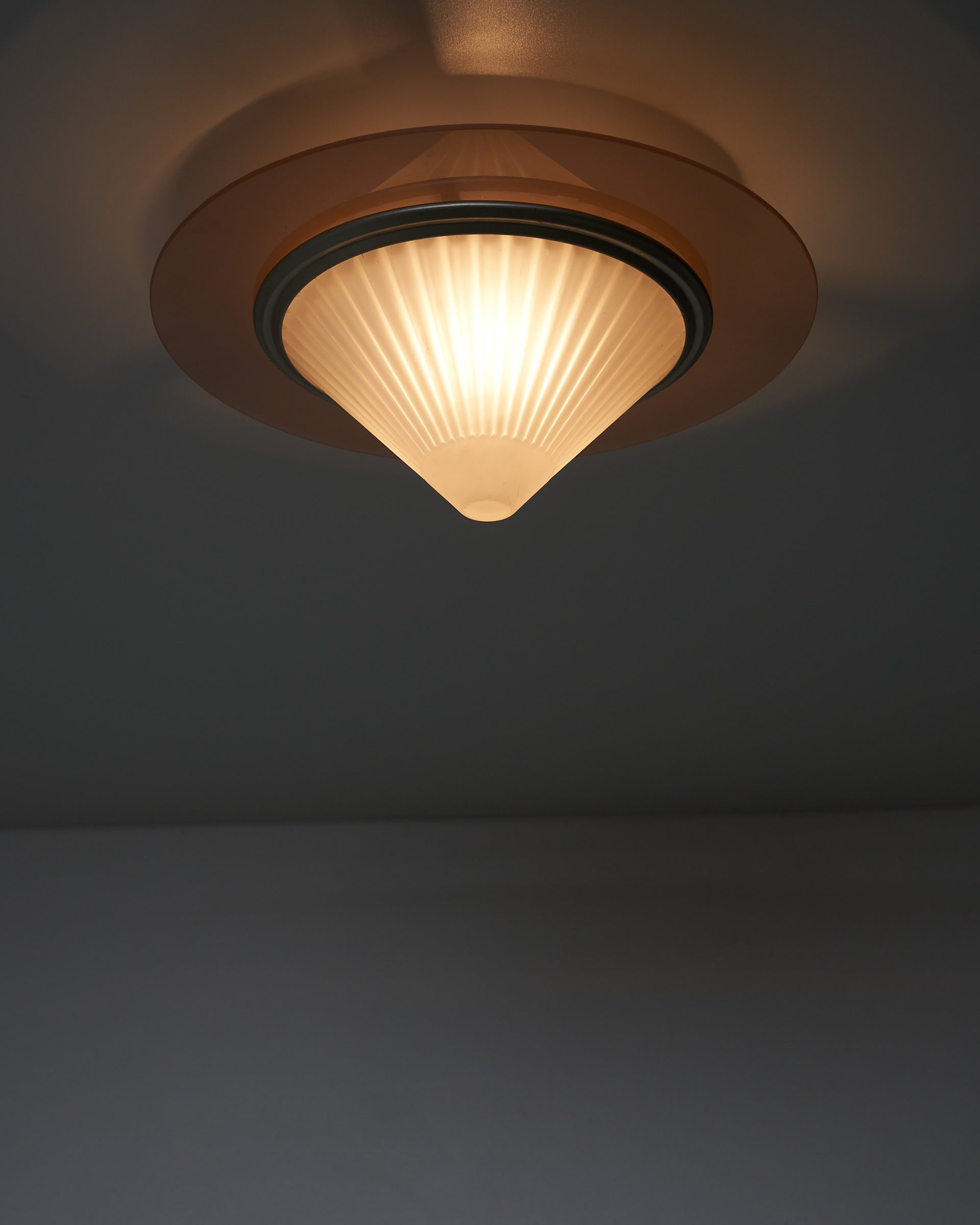 images of the Atena Ceiling Lamp by Ezio Didone for Arteluce, Italy, 1980s. The lamp features a frosted glass cone-shaped diffuser with a colored glass ring around it, separated by a brass ring. The design includes a metal frame that creates a distance between the glass element and the ceiling, producing a backglow effect. The lamp retains its original sticker.