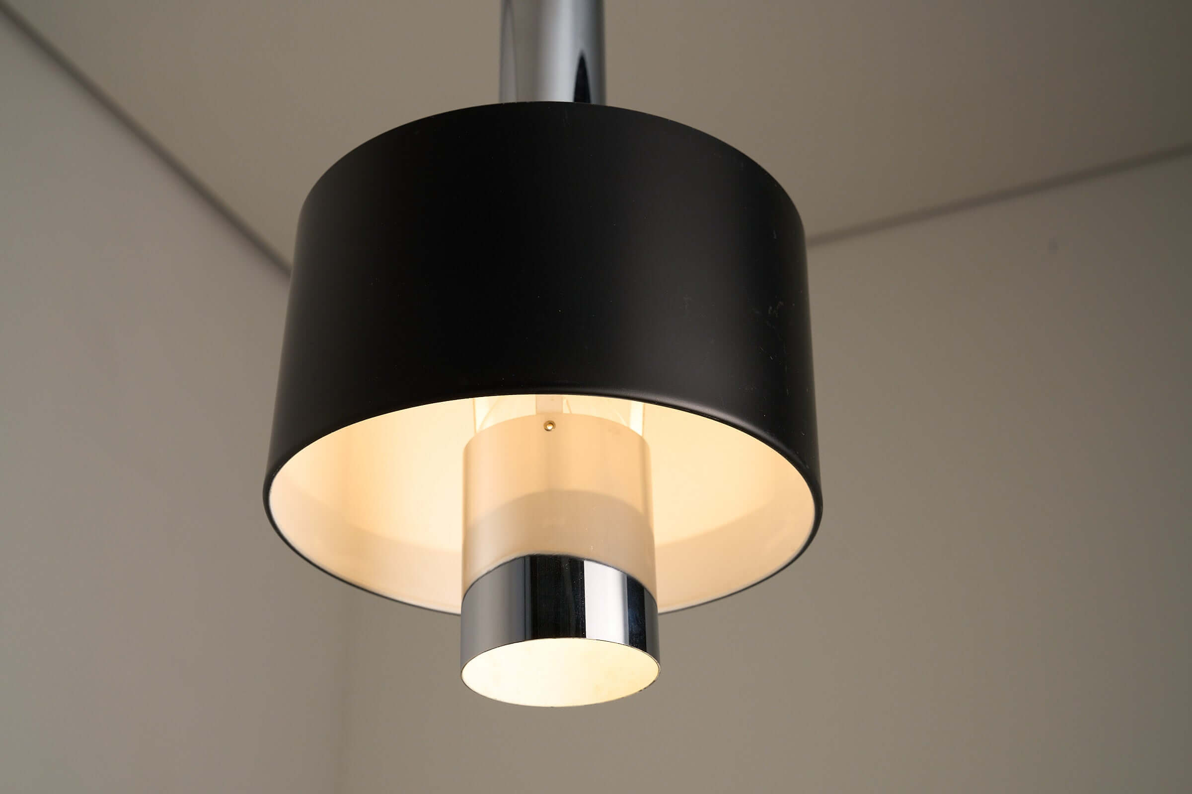 Black pendant lamp with polished chrome inner frame and matte black diffuser, showcasing a sleek, modern 1960s mid-century design.