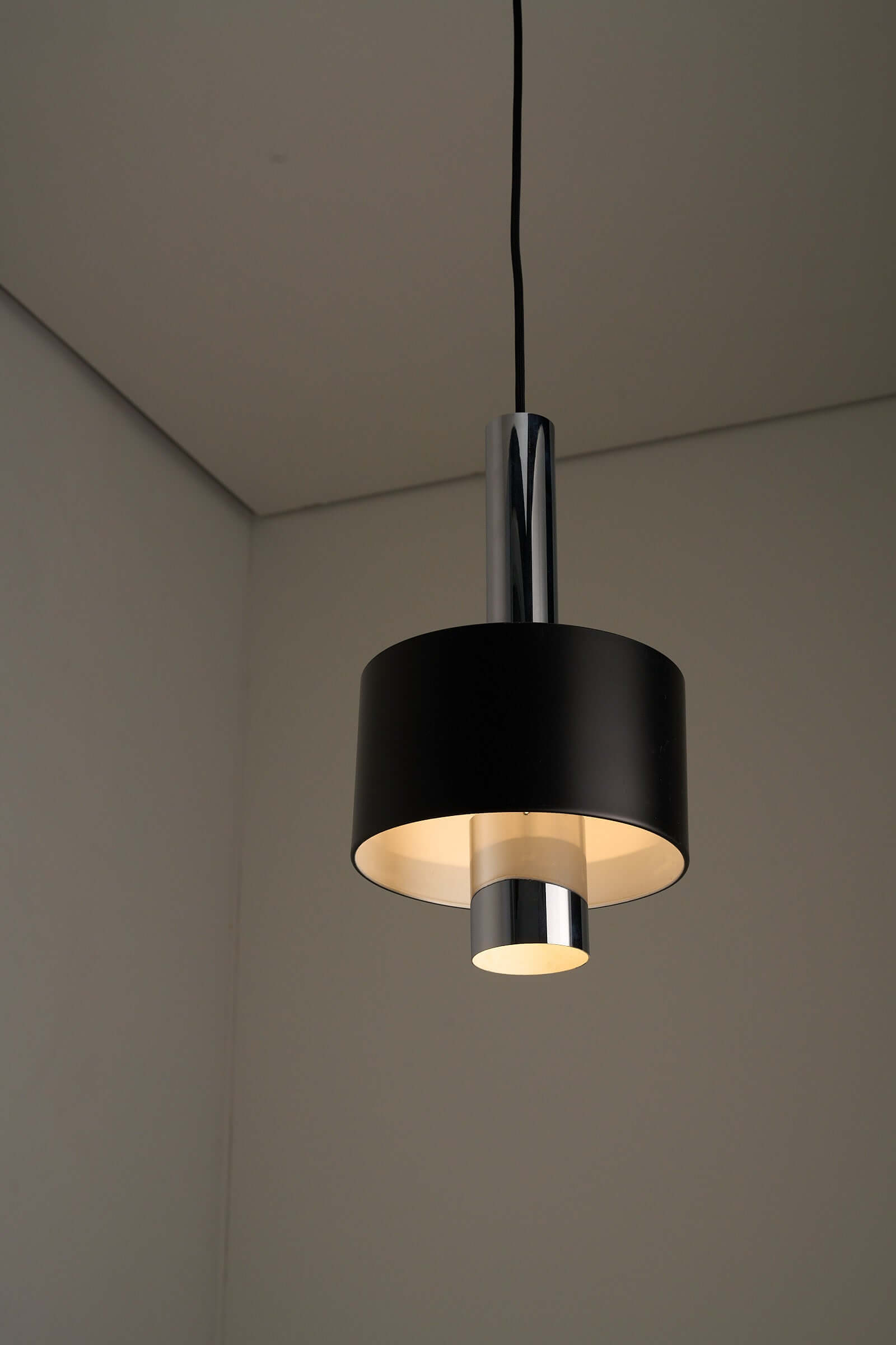 Black pendant lamp with polished chrome inner frame and matte black diffuser, showcasing 1960s vintage mid-century modern design.