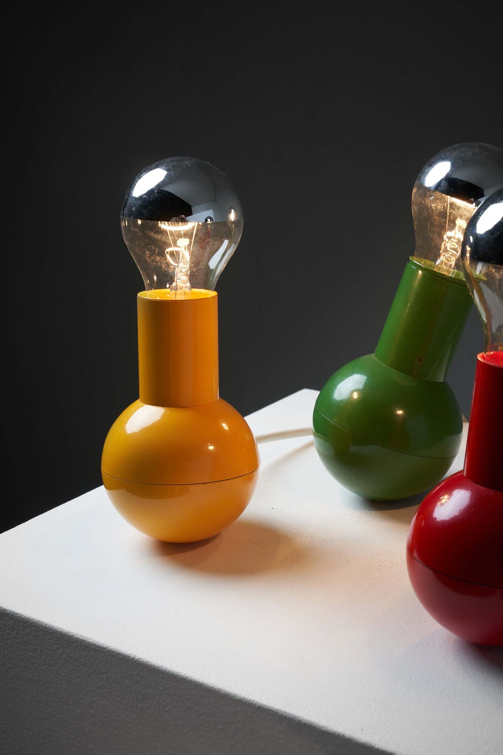 Colorful Kugel Table Lamp Collection showcasing yellow, green, and red bulbous bases with clear bulbs, designed by Cosack Leuchten