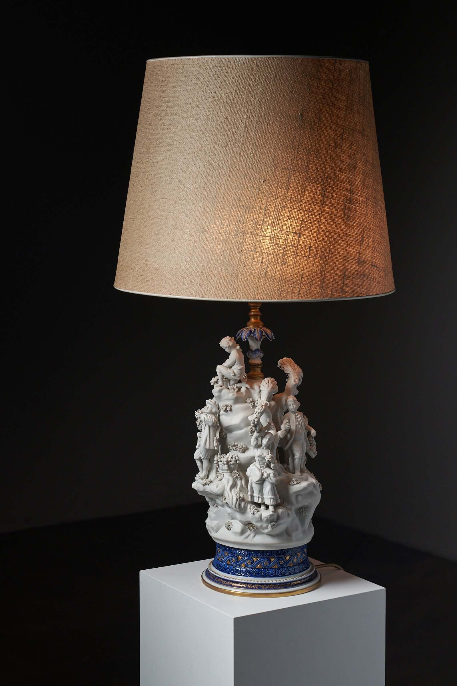 Porcelain table lamp with sculpted figurines and cobalt blue base by Mangani, Italy.