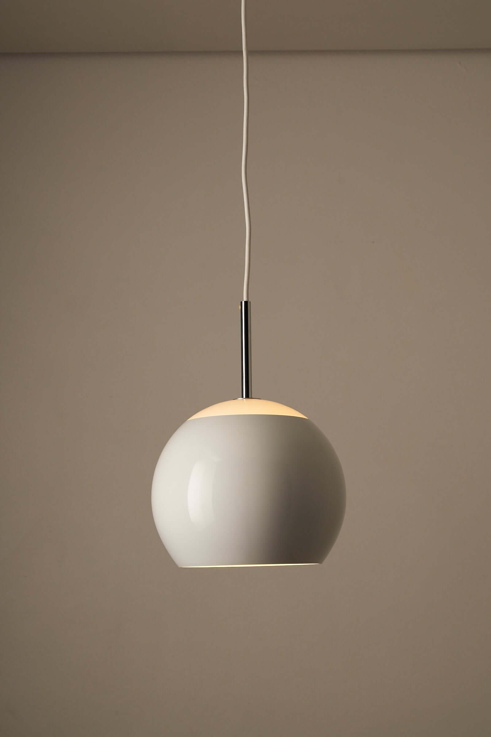 White sphere pendant lamp by Cosack with chrome stem, showcasing elegant design and soft glowing effect.