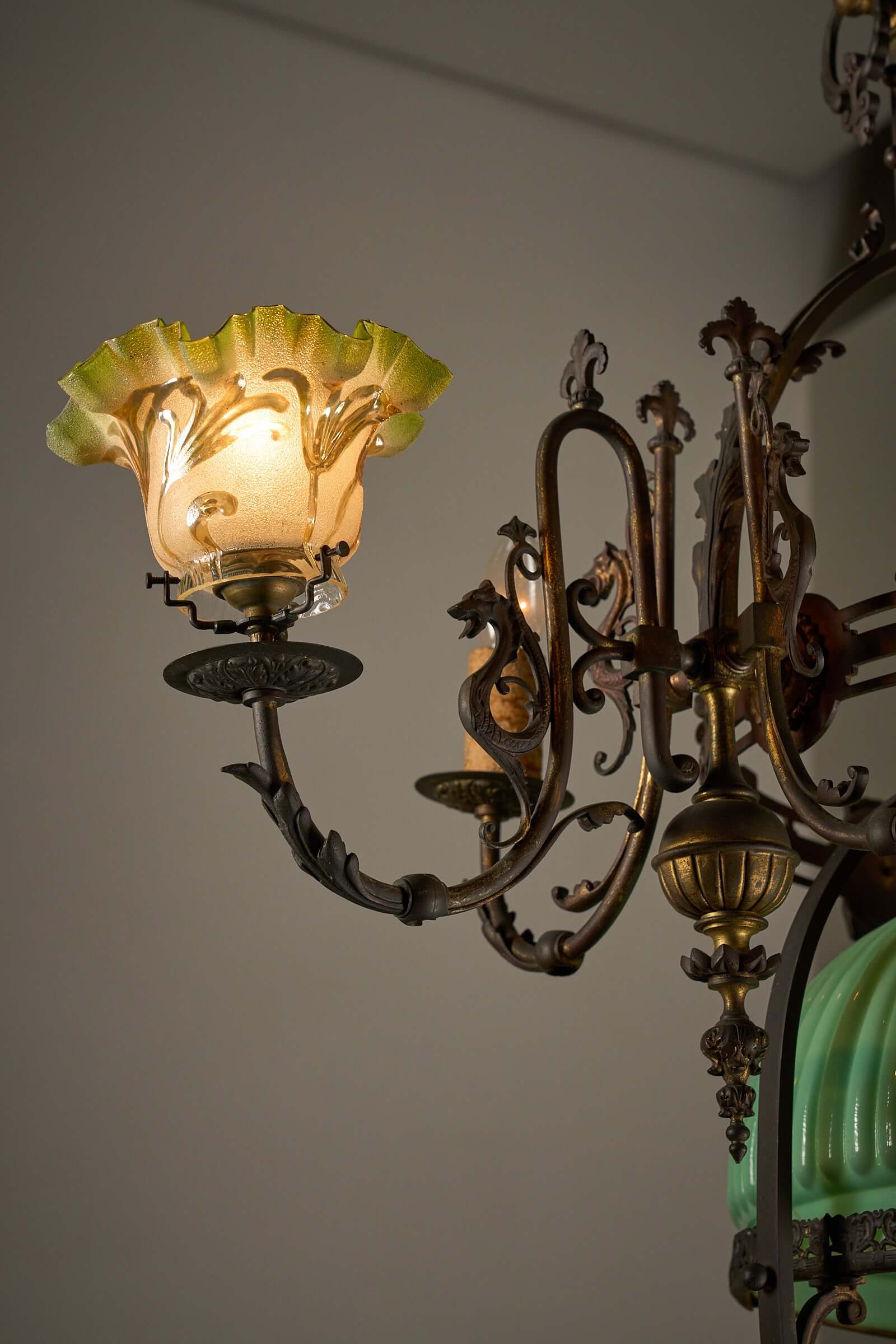 Antique adjustable height chandelier with brass detailing and original glasswork, converted from gas to electric use.