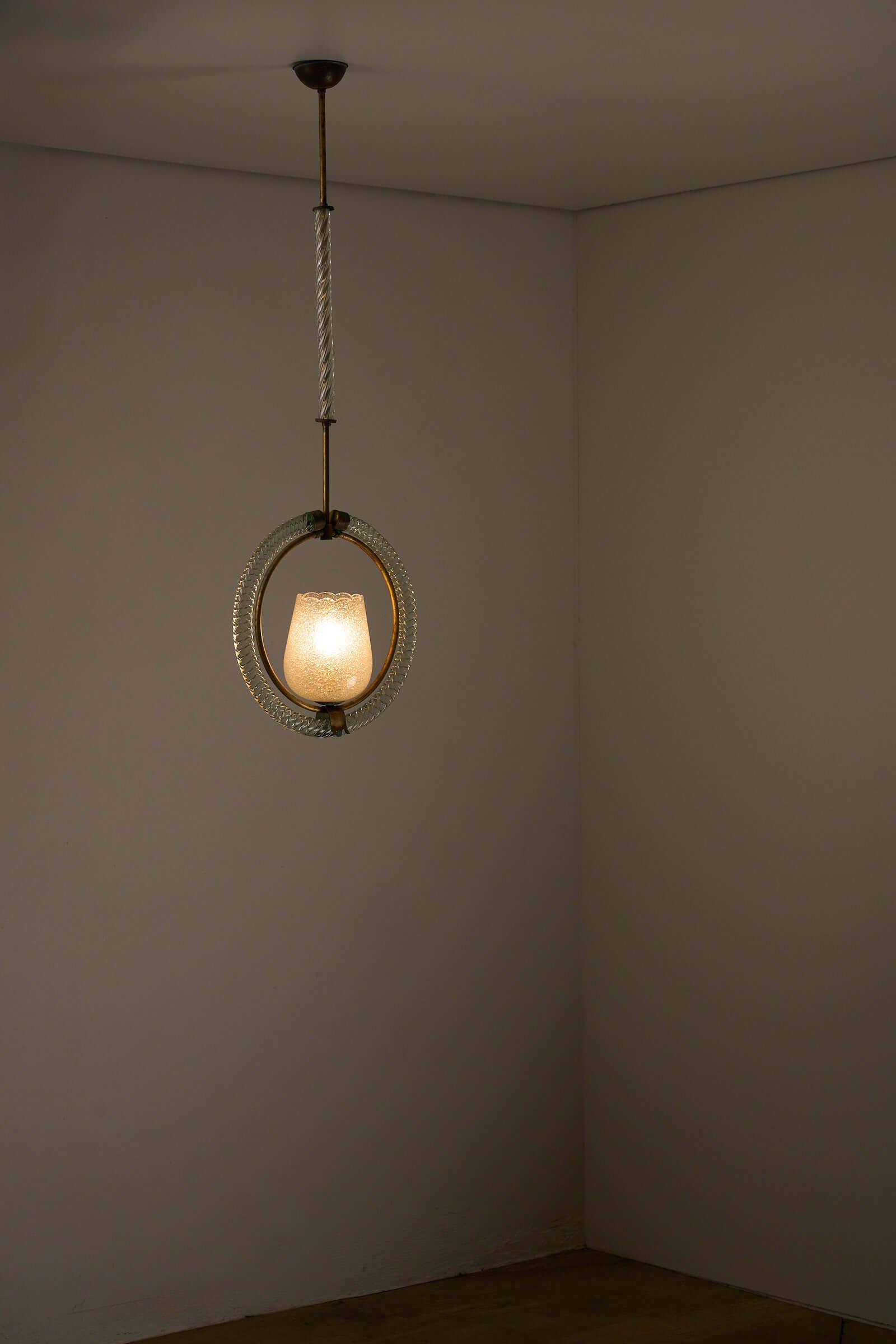 Murano glass and brass chandelier with circular design and textured shade, illuminating a minimalist interior. 1930s Barovier & Toso piece.