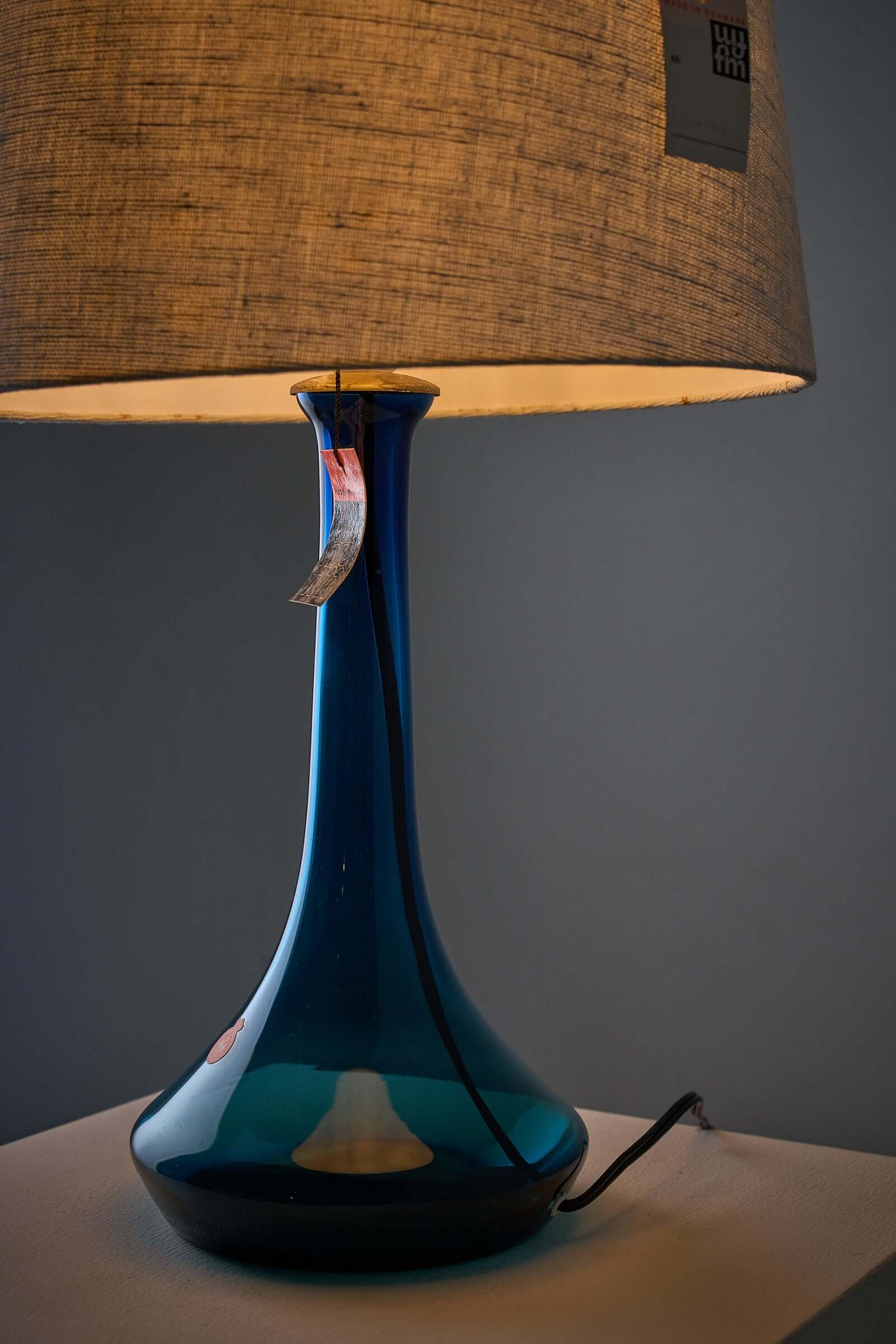 Deep blue Holmegaard glass table lamp with fabric shade, designed by Lisbeth Brams for Fog & Mørup, showcasing mid-century elegance.