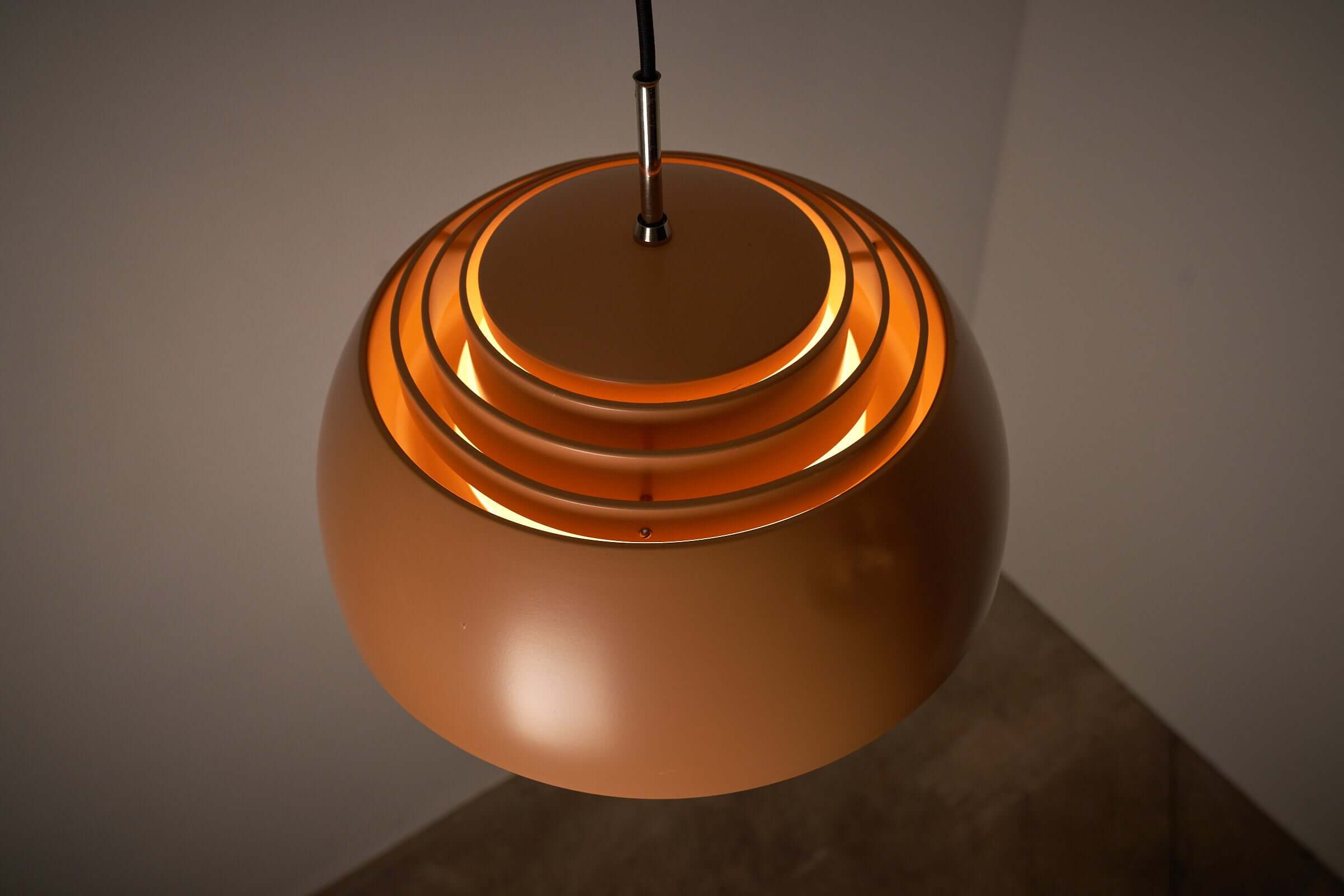 Pendant lamp by B+L Leuchten featuring a sleek orange dome shade with layers for stylish illumination.