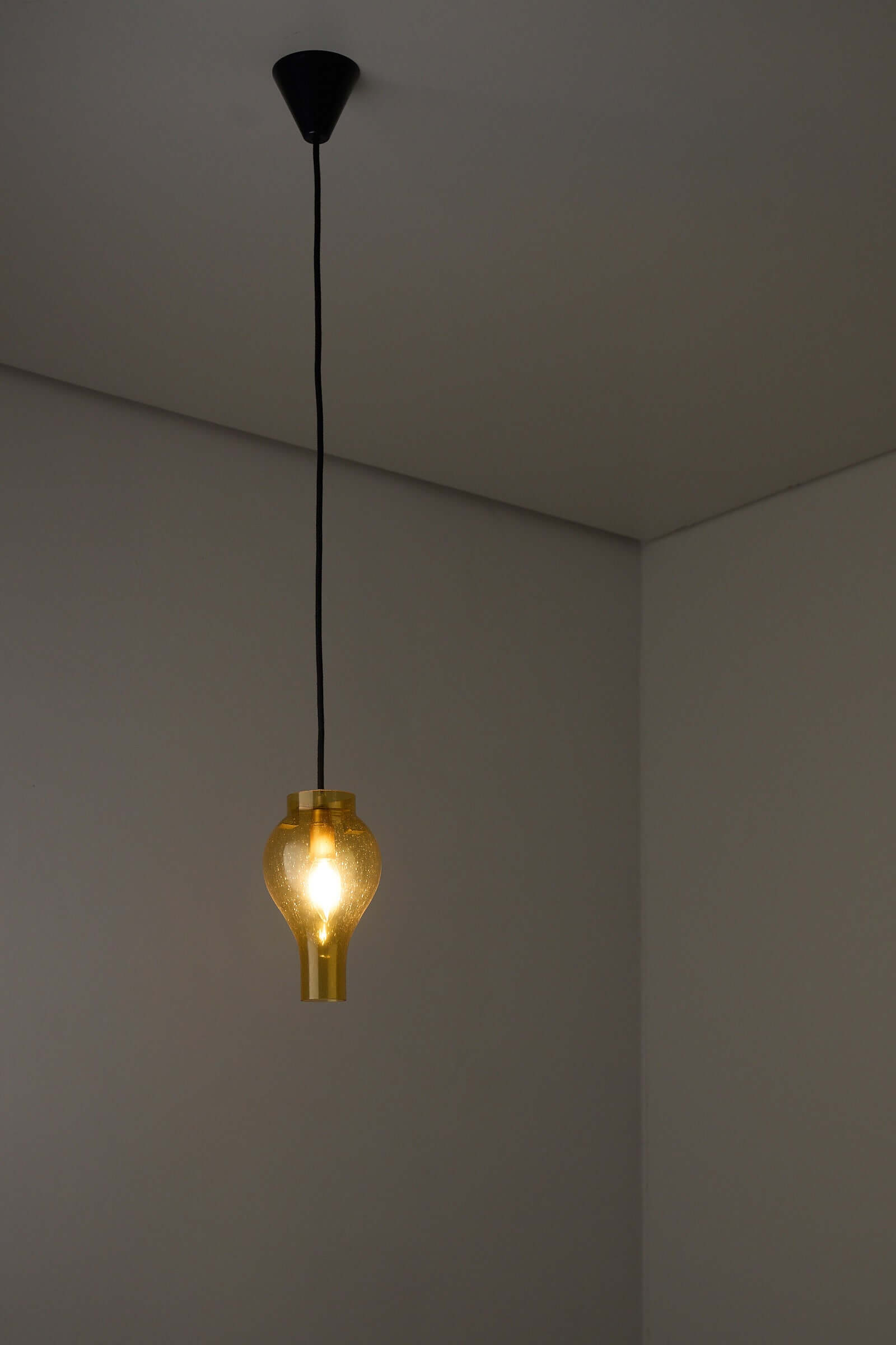 Elegant yellow glass pendant lamp with bubbles illuminating a modern interior space.