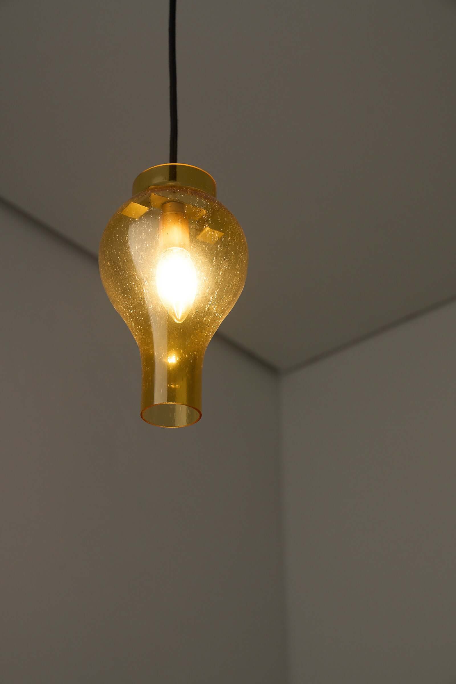 Elegant yellow glass pendant lamp with bubbles illuminating a modern interior.