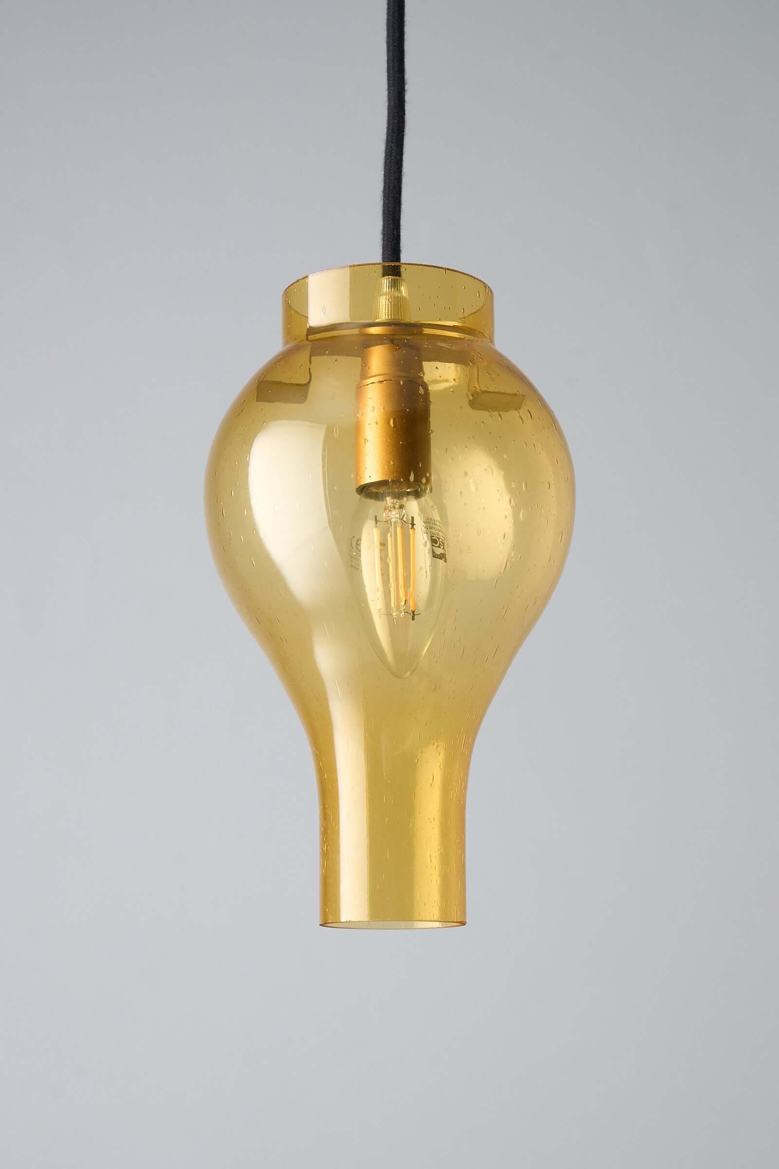 Elegant yellow glass pendant lamp with bubbles, casting a warm glow, perfect for contemporary or vintage interiors.