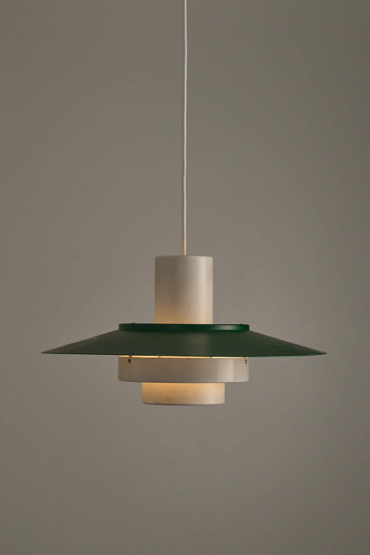 Vintage Falcon pendant light by Andreas Hansen featuring green lacquered shade and white cylindrical core.