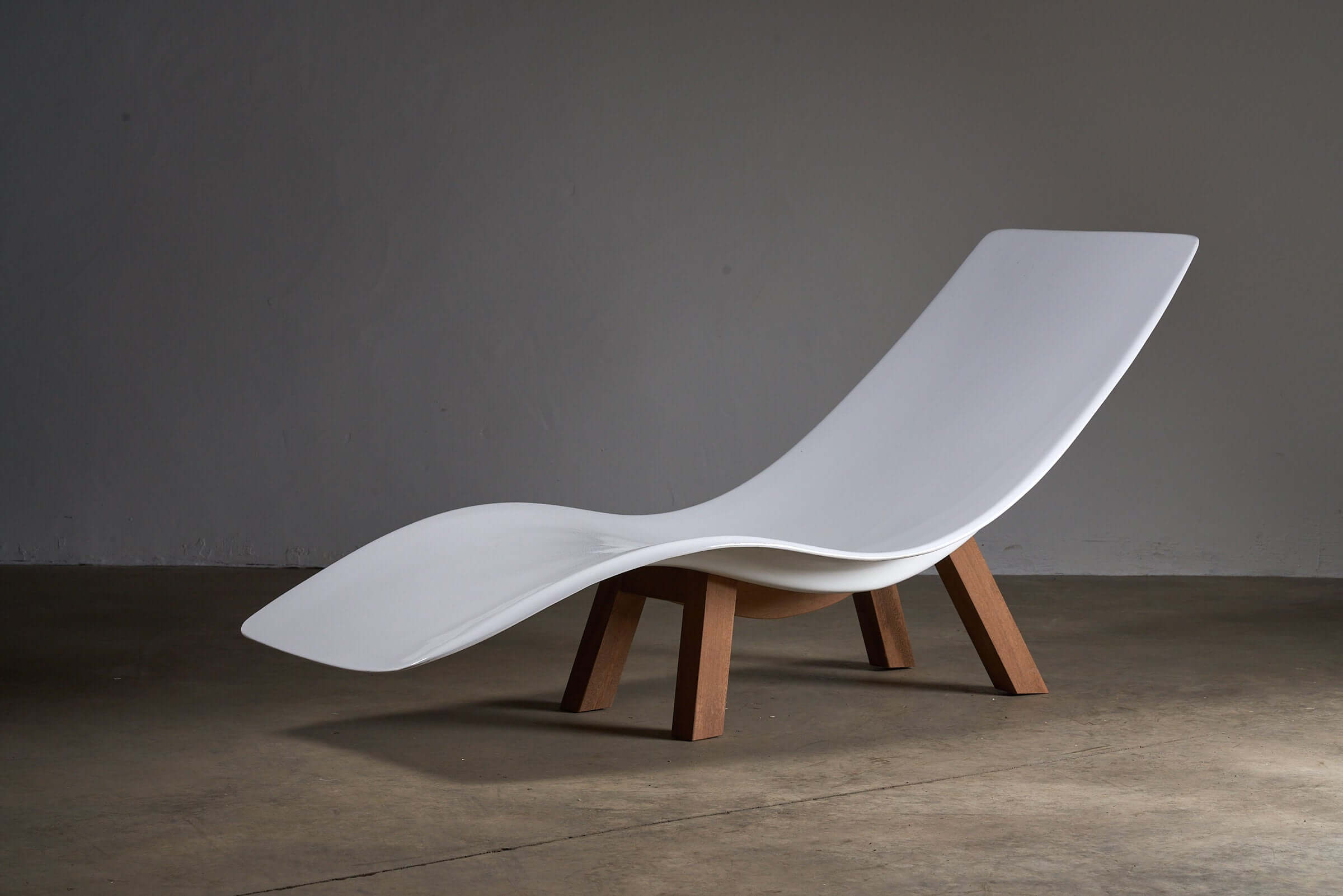 Eurolax R1 chaise longue by Charles Zublena, featuring a sleek white fiberglass design with a solid wood base, embodying mid-century modern style.