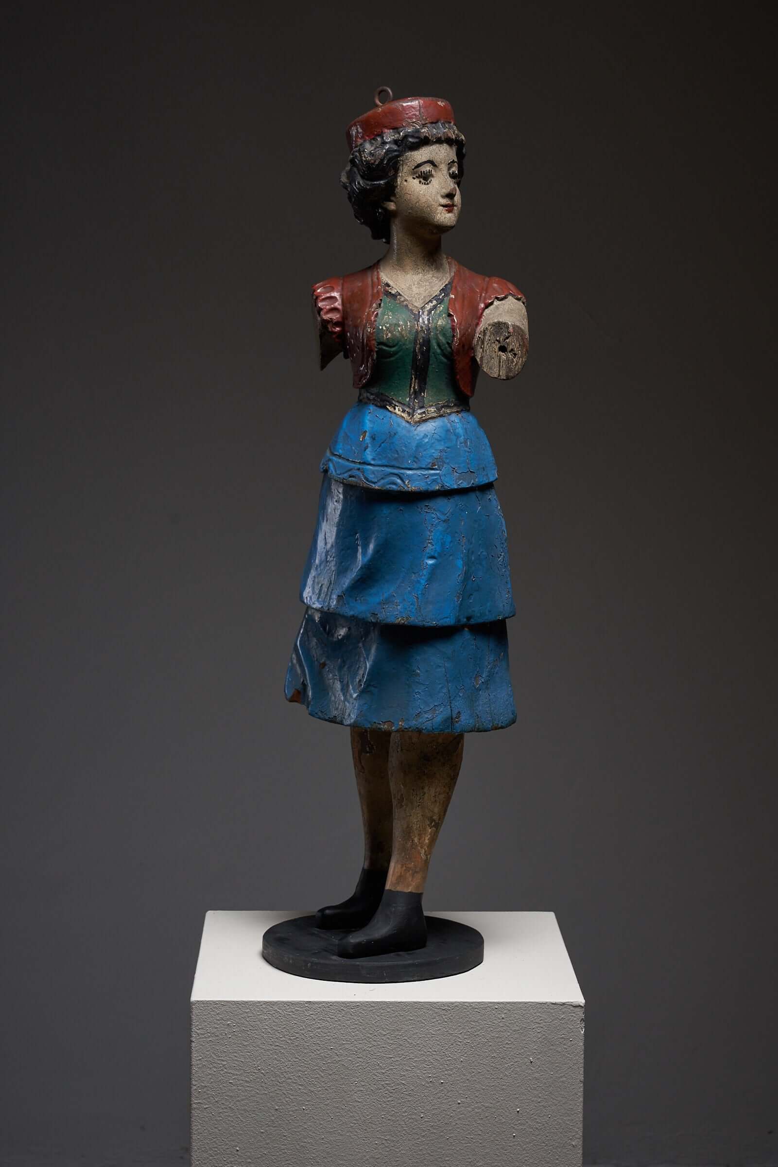 Antique hand-painted wooden lady carousel figure in blue skirt on display