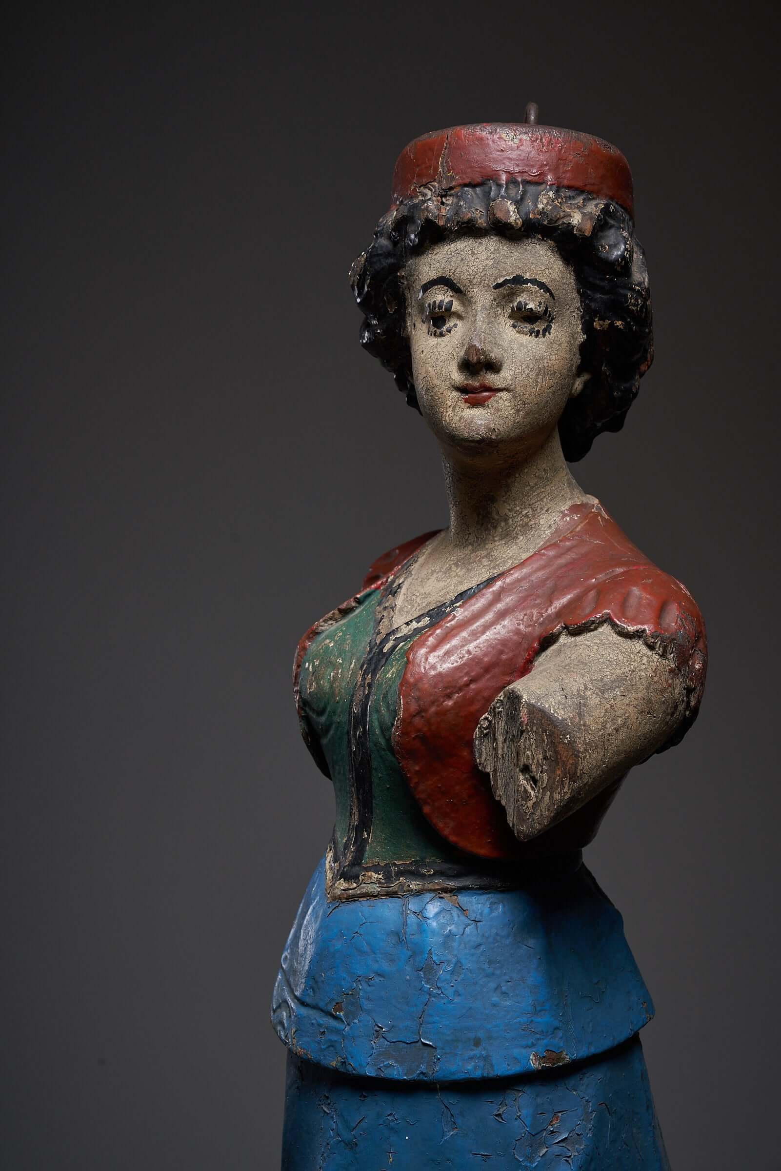 Hand-painted antique carousel lady figure in blue skirt, early 20th-century wooden sculpture with vibrant colors and intricate details.