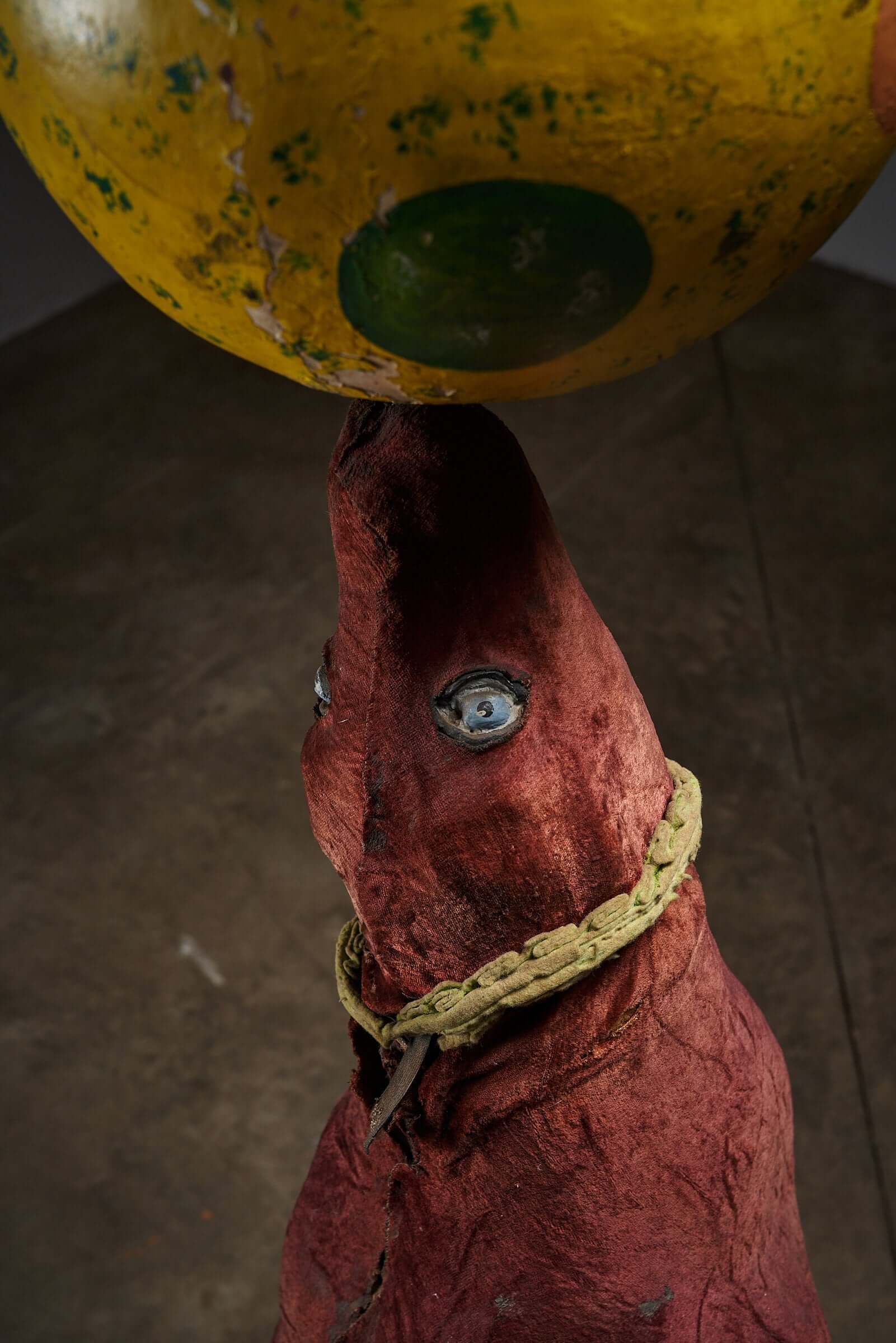 Antique hand-painted wooden circus seal balancing a colorful ball, showcasing vintage art with worn red, yellow, and green colors.