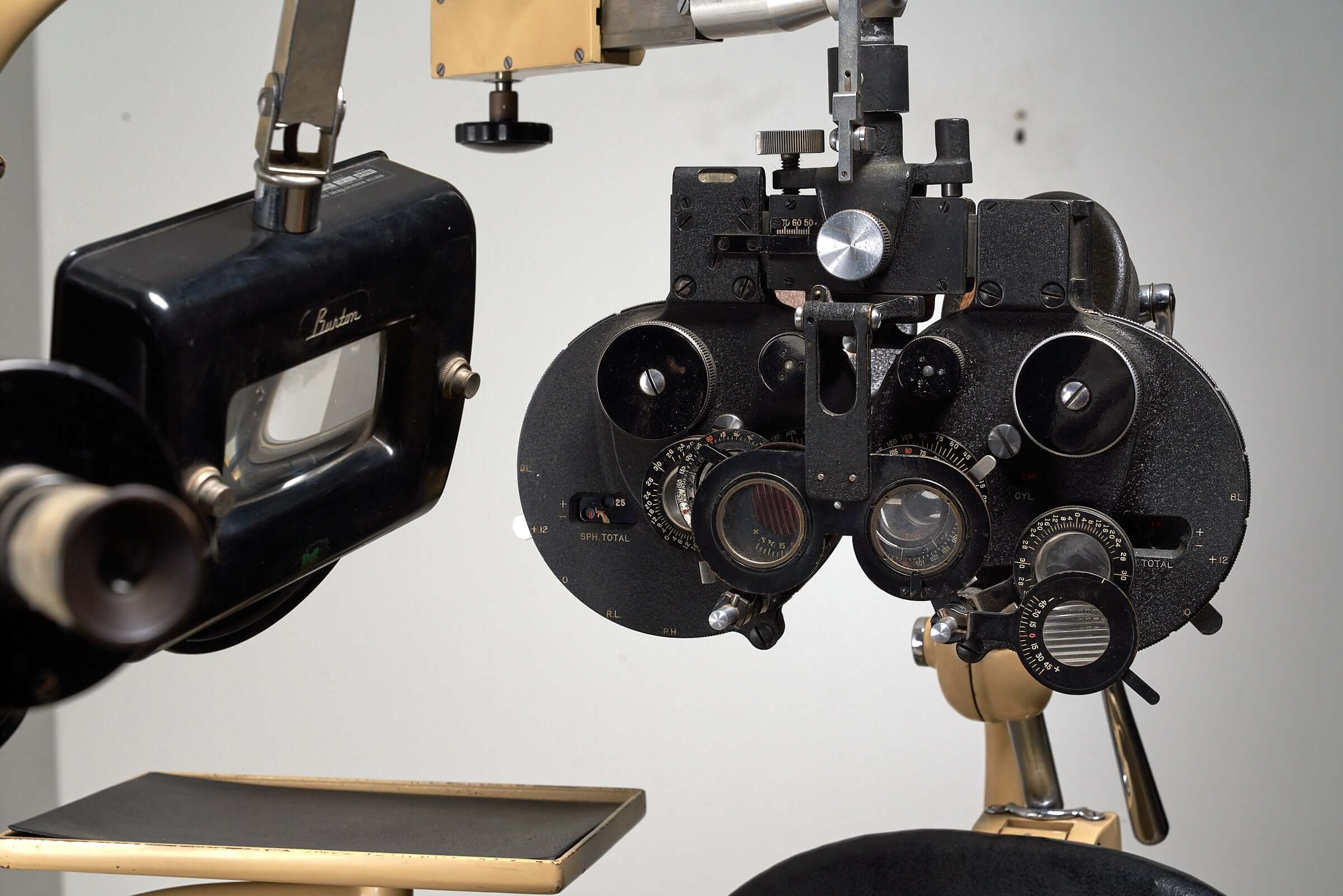 Vintage 1950s optometry examination equipment featuring classic black and beige tones in a medical apparatus setting.