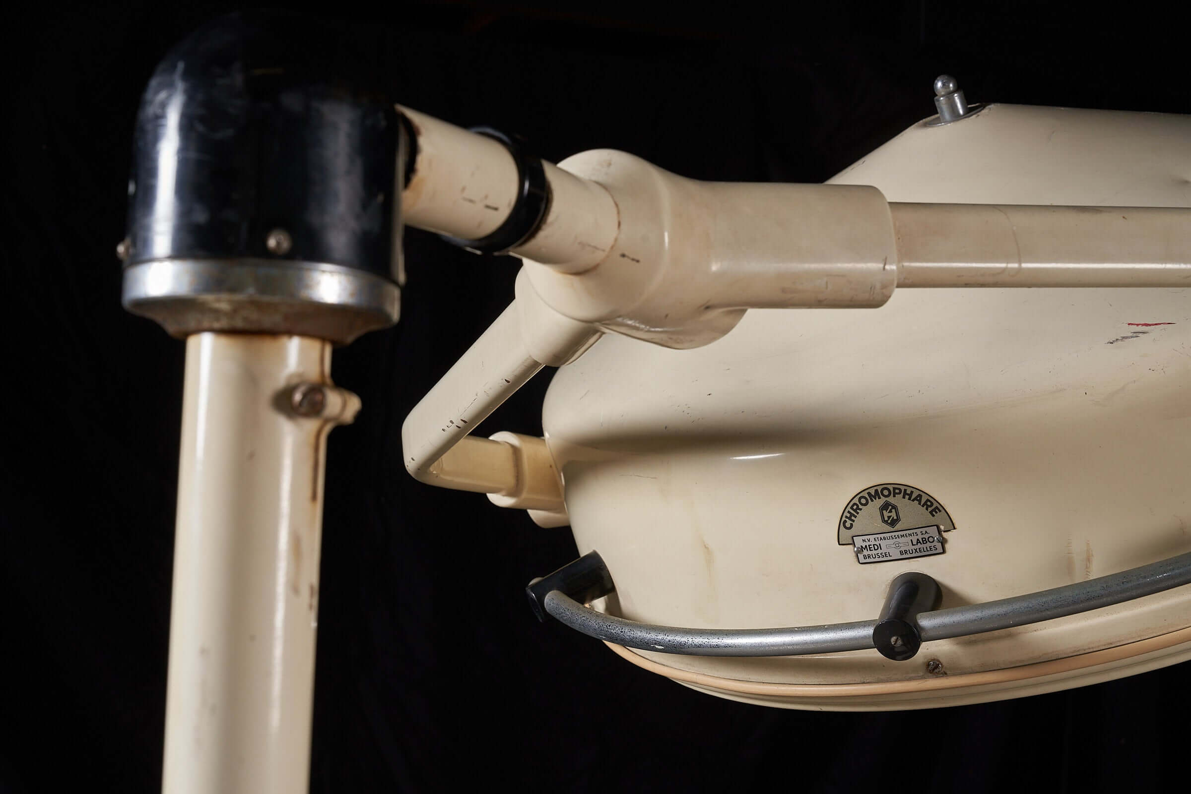 Close-up of vintage cream medical lamp by Chromophare showcasing its adjustable stand and industrial design.