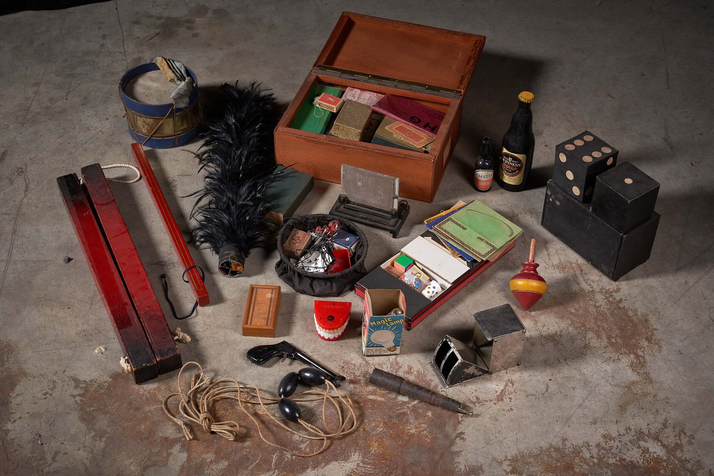 Vintage magician's tool collection with assorted magic props and accessories, featuring a magician's hat, wand, cards, and more.