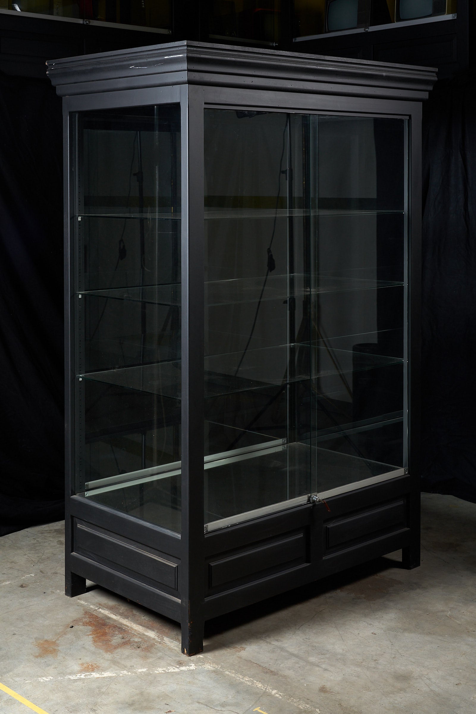 Elegant vintage black display cabinet with glass panels and multiple shelves for showcasing collections or products.