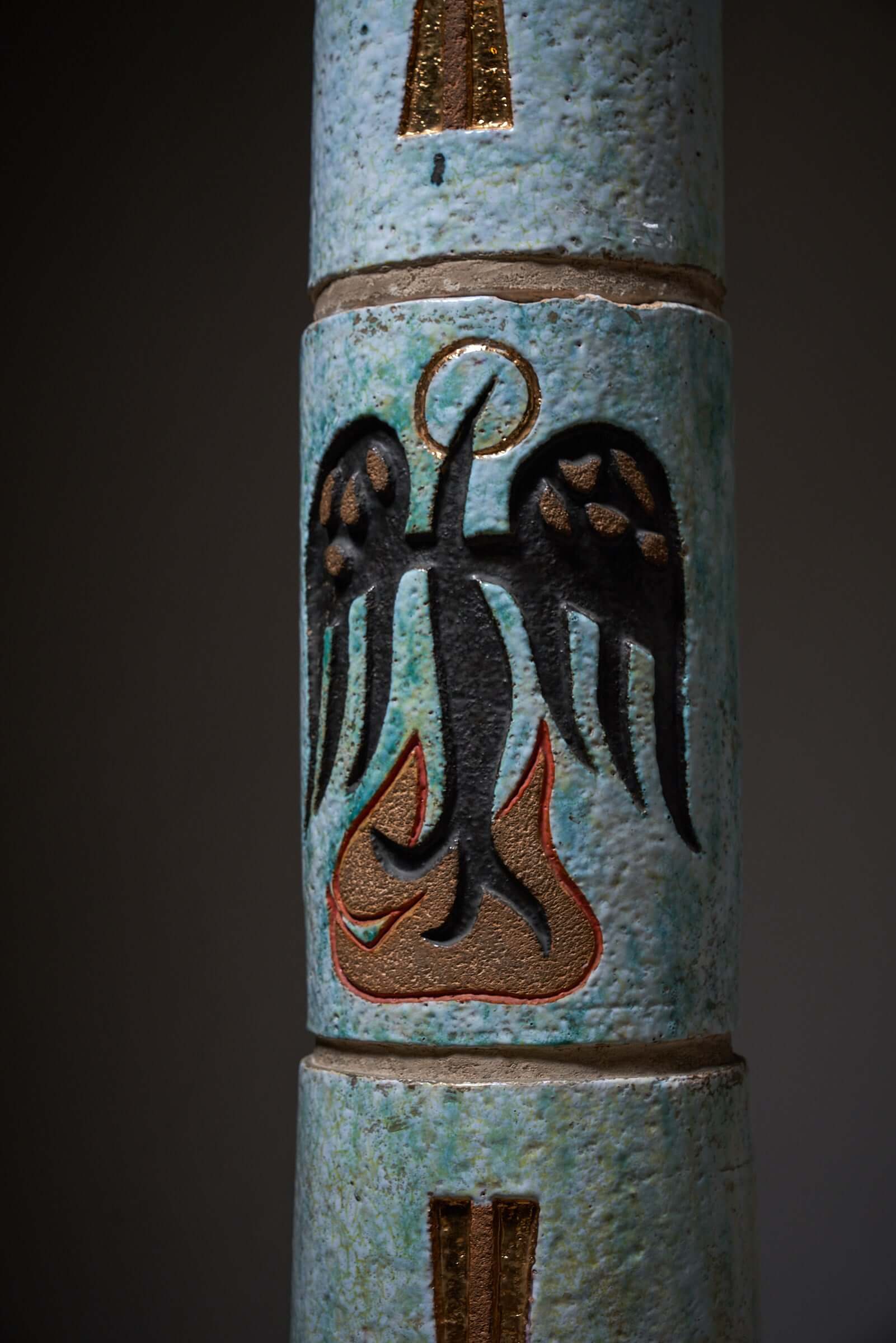 Multicolored ceramic totem with Christian Holy Spirit symbol, detailed with crosses, Alpha and Omega, representing faith and spirituality.